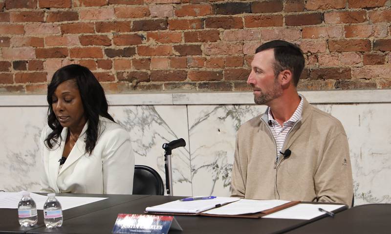 Republican candidate for county judge-executive, Justin Charles, right, listens as his Democratic opponent, Vaché King, reads her opening statement.