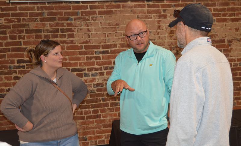 Jim Caldwell, center, a Winchester commission candidate, converses with Brent and Michelle Peterson.