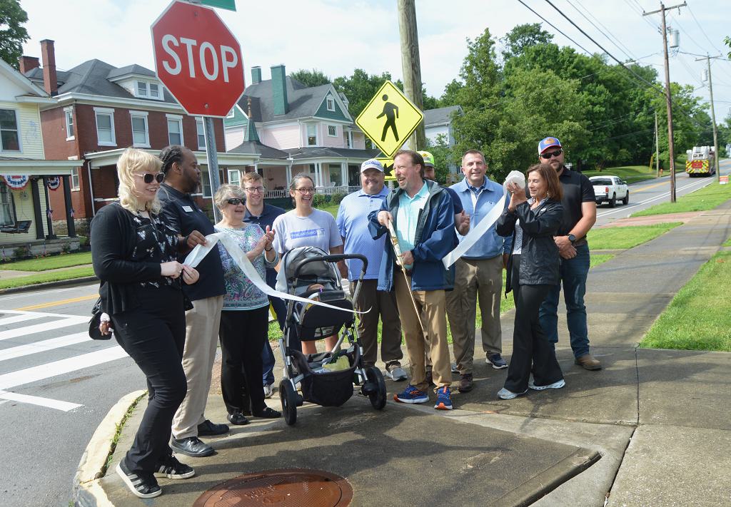 Community leaders gather on Boone Avenue for a ribbon-cutting Monday to dedicate the Safer Boone quick-build project, funded by a $20,000 Smart Growth America grant.