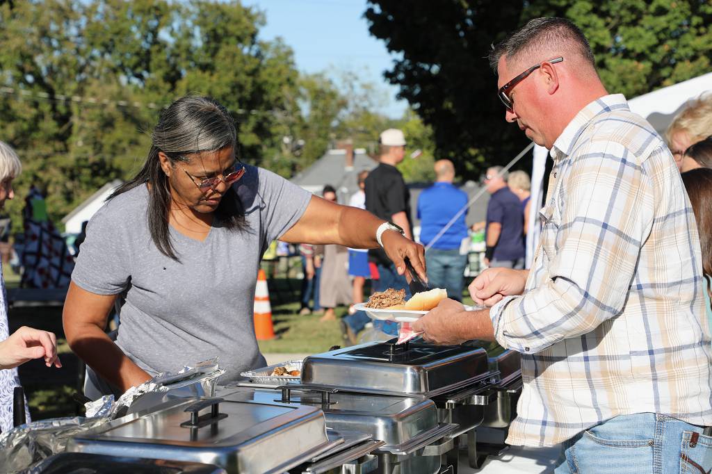 Darlene Larry, left, serves Dustin Miller in the food line at Holly Rood’s annual fall barbecue fundraiser. (Randy Patrick)